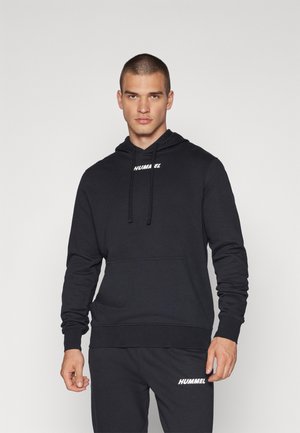 Zwarte hoodie met trekkoord en een voorzak, voorzien van een wit Hummel-logo op de borst. Gemaakt van zachte stof met lange mouwen.
