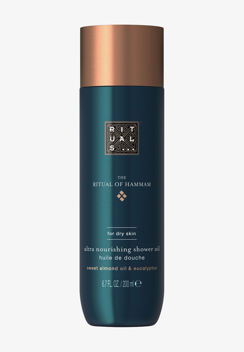 Hoge donker groene fles met een koperen dop met het etiket Ritual of Hammam ultra voedende doucheolie voor droge huid, zoete amandelolie en eucalyptus, 200 ml.