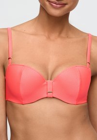 Reggiseno a fascia rosa corallo con texture a coste verticali, supporto con ferretto, spalline regolabili e chiusura metallica al centro davanti.