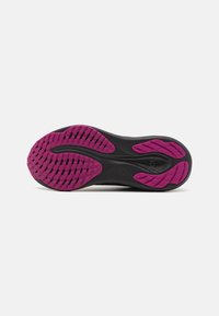 Semelle de chaussure de sport noire avec des accents en caoutchouc rose et un motif de grip texturé. Comprend des rainures pour la flexibilité et la traction.