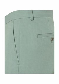 Hellgrüne Hose mit glatter Textur, schmalem Bund, seitlicher Tasche und einer einzigen Gesäßtasche mit einem braunen Knopfdetail.