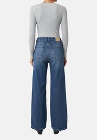 Weite blaue Jeans aus Denim, mit hoher Taille, Fünf-Taschen-Design und einem Leder-Logo-Patch auf der Rückseite.