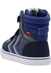 Marinblå högskurna sneakers med en blandning av mocka och läder, kardborreband, kontrasterande vita ränder och en vit sula.