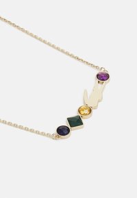 Gouden ketting met vier gekleurde edelstenen: paars, geel, groen en donkerblauw. Het ontwerp van de ketting is eenvoudig en delicaat.