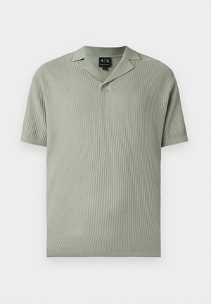 Lichtgroene trui met korte mouwen, van het polo-type, met een textuurpatroon en één knoop onder de open kraag.