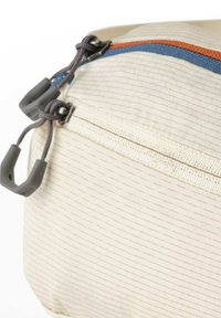 Hellfarbene Tasche mit einer strukturierten Oberfläche, ausgestattet mit einem blauen und orangefarbenen Reißverschluss, grauen Zuglaschen und einem mehrschichtigen Design mit feinen Linien.