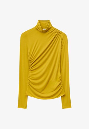 Musztardowożółta bluzka z długim rękawem i golfem, z marszczeniami na lewej ramieniu i prawej talii, wykonana z gładkiego materiału.