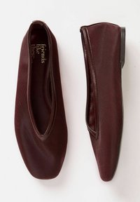 Burgunderfärgade ballerinas med en mjuk textilöverdel, öppen halsdesign och diskreta sömdetaljer. Sulan är svart och något strukturerad.