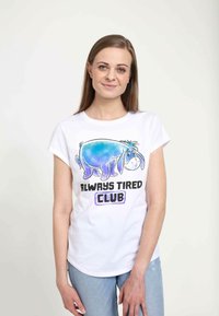 Bílá bavlněná tričko s modrou grafikou Eeyora a textem "ALWAYS TIRED CLUB" pod tím v černé a fialové barvě. Krátké rukávy, uvolněný střih.
