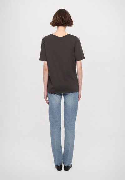 Mørk grå kortermet t-skjorte med rund hals, kombinert med lyseblå rette jeans og svarte ankelsko.