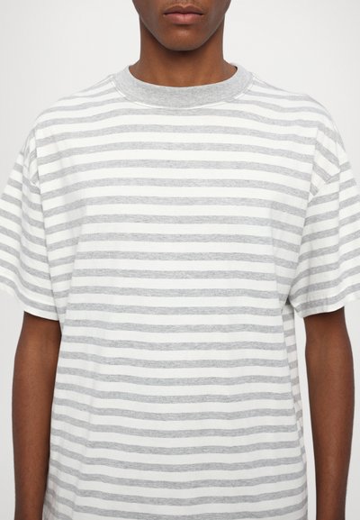 Gray and white striped t-shirt made of soft cotton, featuring a round neckline and short sleeves with a relaxed fit.