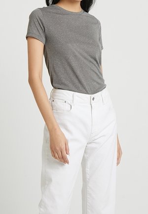 Camiseta gris de manga corta con un tejido ligeramente texturizado, combinada con unos jeans de denim blancos de cintura alta que tienen un corte clásico y botones en la parte delantera.