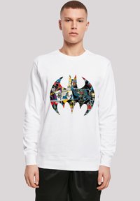 Hvid bomulds sweatshirt med et stort sort flagermus-symbol fyldt med farverig tegneserie-illustration. Rund hals og ribbede manchetter.