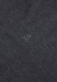 Mørkegråt stof med subtilt broderet dødningehoved og korslagte knogler-logo i matchende tråd centreret i rammen.