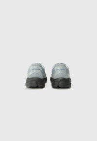 Grijze gaas- en synthetische sneakers met zwarte rubberen zolen. Beschikt over een gestructureerd ontwerp en "LACOSTE" branding in het blauw op de hiel.