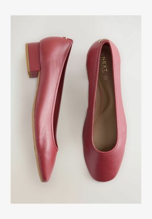 Punat ballerina nahkaa, joissa on matala lohkoakseli, pyöreä varvas ja avoimet sivut. Pehmeä pinta ja minimalistinen muotoilu kultaisilla yksityiskohdilla.