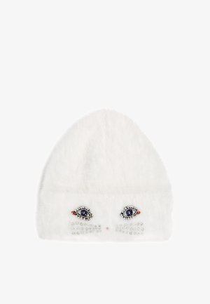 White faux fur beanie featuring embroidered eye design and rhinestone accents on the front, with a rounded top and textured finish.