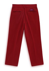 Pantaloni rossi a gamba dritta in cotone con due tasche posteriori. Presentano un'etichetta con il logo Vans viola sul lato destro. Tessuto liscio.