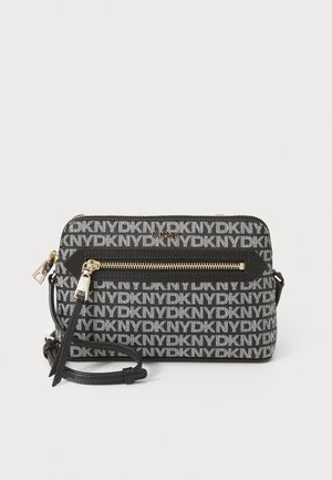 Black and white pouch bag features DKNY logo pattern, gold hardware, and zippered compartments. Includes a detachable shoulder strap.