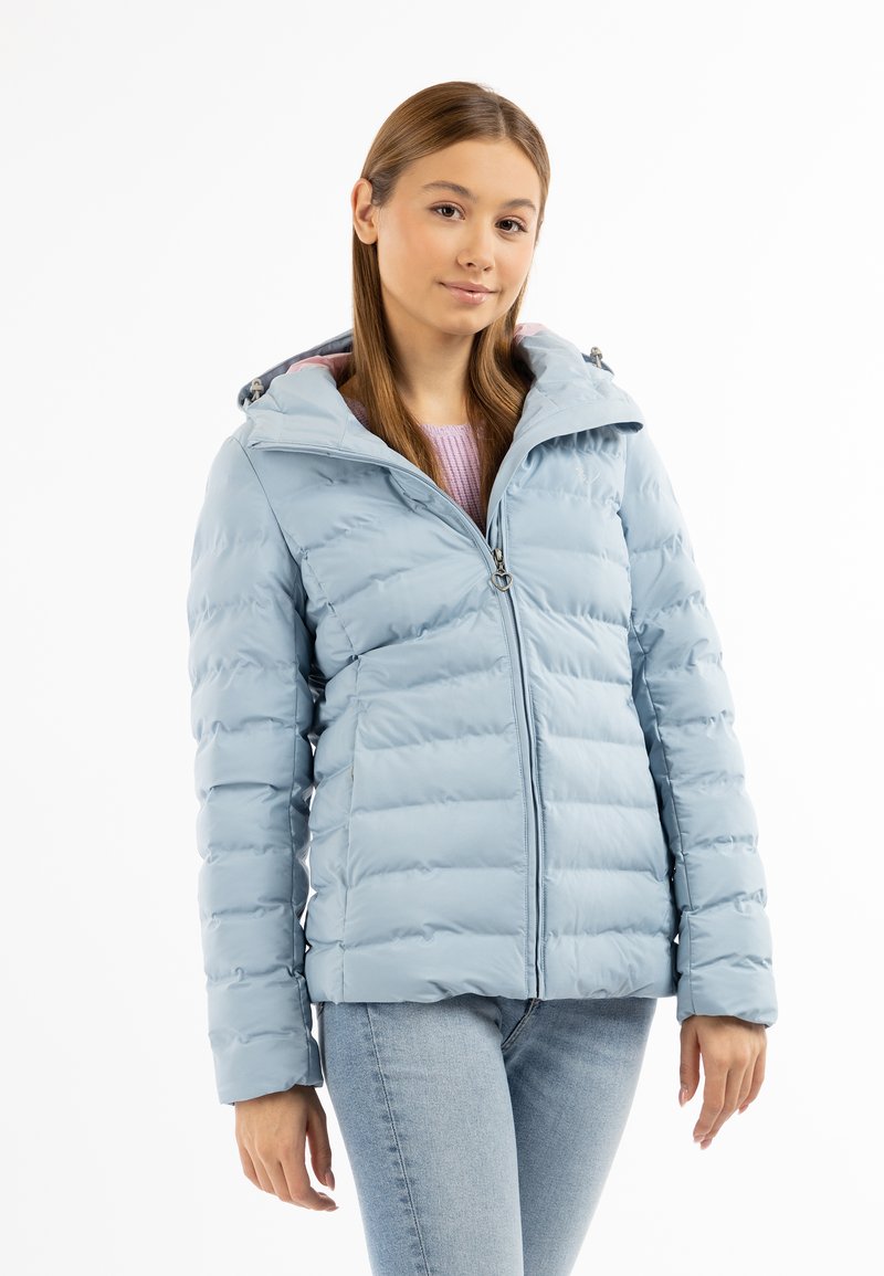 Giacca imbottita blu chiaro con texture a cucitura orizzontale, chiusura con zip e cappuccio, abbinata a un top in maglia rosa e jeans chiari.