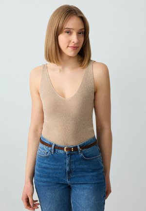 Bodysuit beige côtelé avec un décolleté en V profond, porté avec un jean en denim bleu taille haute et une ceinture marron, présenté sur un fond neutre.