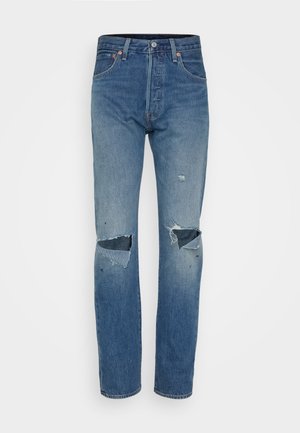 Soehe sinine rebenditega teksad, mis on sirge jala disainiga, frantsiinadega põlvekohad ning klassikaline viie taskuga stiil koos metallist riistadega.