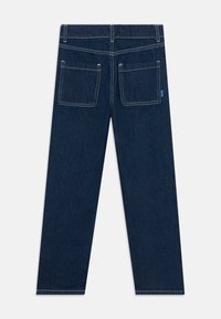 Jeans de mezclilla azul oscuro con perneras rectas, dos bolsillos traseros con parche, costuras blancas y una pequeña etiqueta azul en el bolsillo derecho.