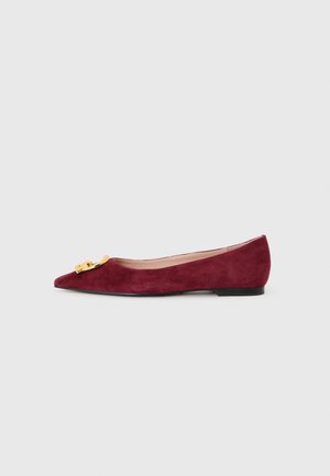 Burgundy suede ballet flat with a pointed toe, featuring a gold-tone hardware accent on the upper and a low black heel.