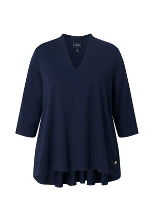 Top blu navy a maniche tre quarti con scollatura a V. Tessuto morbido e orlo asimmetrico svasato. Presenta un piccolo accento con logo dorato.