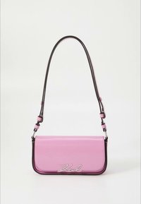 Rožnato usnjena torbica z gladko teksturo, nastavljivim trakom in srebrnim logotipom "Karl" na sprednji strani. Ima črne poudarke ob robovih.