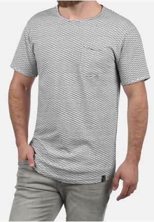 T-shirt a maniche corte a righe in bianco e nero, con scollatura rotonda e taschino sul petto. Tessuto morbido con un motivo testurizzato.