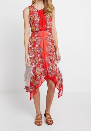 Red and white patterned dress with a sleeveless design, featuring a handkerchief hem. Made of lightweight fabric with intricate paisley details.