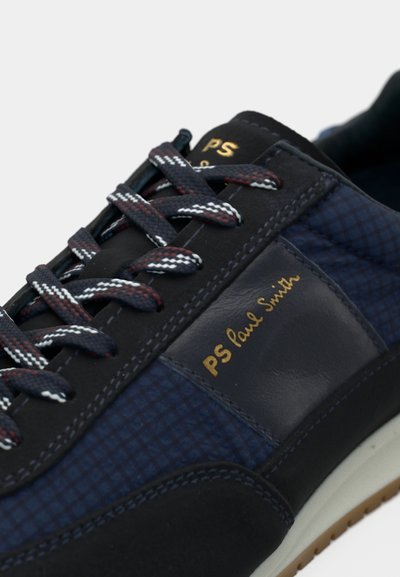 Baskets bleu marine en matériaux mixtes : tissu texturé à motif écossais et cuir lisse. Marque dorée et lacets multicolores.