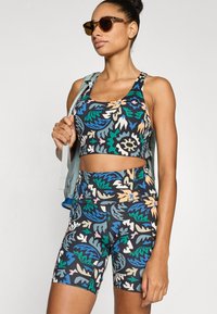 Σετ αθλητικό σουτιέν και σορτς με ψηλή μέση, με πολύχρωμο φύλλωμα σε μαύρο φόντο, κατασκευασμένο από ελαστικό ύφασμα, με εφαρμοστή σχεδίαση.