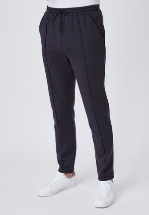 Pantaloni da sudore neri con vita elasticizzata e cordino, dotati di tasche laterali oblique e vestibilità slim, realizzati in tessuto morbido.