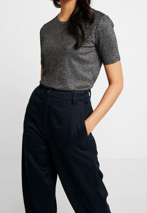 Top aderente a maniche corte di colore grigio scuro con una texture scintillante, abbinato a pantaloni blu navy a vita alta con tasche anteriori.