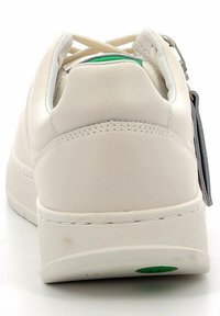 Zapatilla de cuero blanca con una textura suave, tacón redondeado y un diseño minimalista. Presenta un acento gris y un detalle del logo verde en la suela.