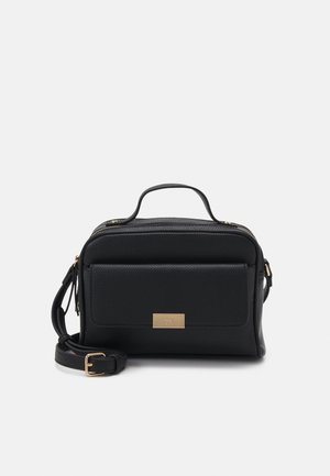 Sac à main en cuir noir avec fermeture éclair, doté d'une poche avant, d'une surface texturée, de ferrures dorées et d'une bandoulière amovible.