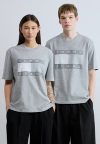 Γκρι βαμβακερά t-shirt με έντονο γραφικό σχέδιο σε λευκό και σκούρο γκρι. Χαλαρή εφαρμογή με κοντά μανίκια και στρογγυλή λαιμόκοψη.