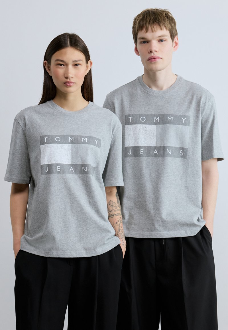 Γκρι βαμβακερά t-shirt με έντονο γραφικό σχέδιο σε λευκό και σκούρο γκρι. Χαλαρή εφαρμογή με κοντά μανίκια και στρογγυλή λαιμόκοψη.