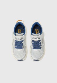 Baskets de sport grises et argentées avec une tige en mesh, des lacets bleus et une sangle avant. Le texte sur la languette indique "SKECHERS GO RUN."