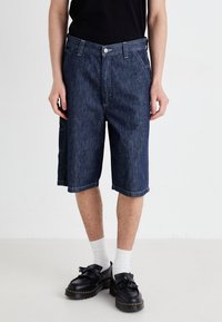Denim shorts in dark blue, featuring a straight cut, front pockets, and a side cargo pocket, finished with contrasting stitching.