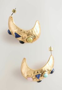Goldene ohrenklingende Ohrringe in Halbmondform mit verschiedenen Edelsteinen: Blau, Grün und Pink. Strukturelle Oberfläche mit auffälligen Akzenten und schlichten Steckerverschluss.