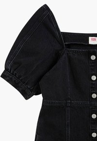 Mustat farkkukankaiset mekko lyhyillä puffi-hihoilla, nappikiinnitys edessä ja jämäkkä muoto. Sisältää hienovaraisia tekstuuri- ja kontrastitikkaukset.