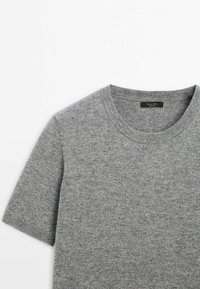 Pull en maille gris chiné à manches courtes avec col rond, fabriqué en tissu doux et texturé, posé à plat sur fond blanc.