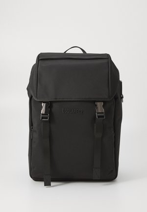 Sort nylon rygsæk med en topklap, sølvhardware, justerbare stropper og præget logo på forsiden. Glat tekstur og rektangulær form.