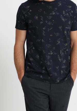 Mørkeblå bomulds t-shirt med et geometrisk mønster i lyseblå og guldtoner; rund hals, korte ærmer og en afslappet pasform.