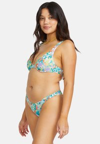 Floral bikini set in pastel colors, featuring a triangle top and high-cut bottoms. Made from smooth fabric with a multicolored flower pattern.