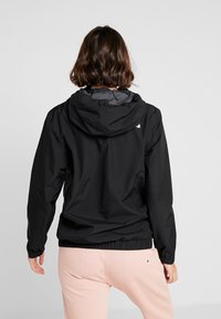 Schwarze leichte Jacke mit Kapuze; elastische Bündchen und Saum; glatte Textur; mit kontrastierender Innenausstattung.