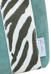 Groene suède tas met een wit en groen zebrapatroon, voorzien van een lichtblauw label met de merknaam in het roze.